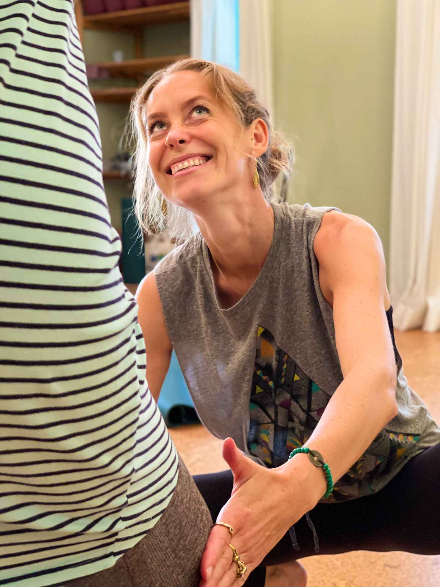 Eine Yogalehrerin zeigt einer Frau die korrekten Asana-Ausführung während einer Yoga-Privatstunde